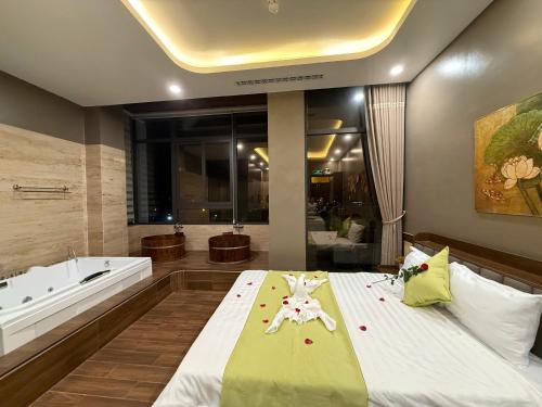 a bedroom with a tub and a bed with flowers on it at MD Hotel in Mỹ Lộc