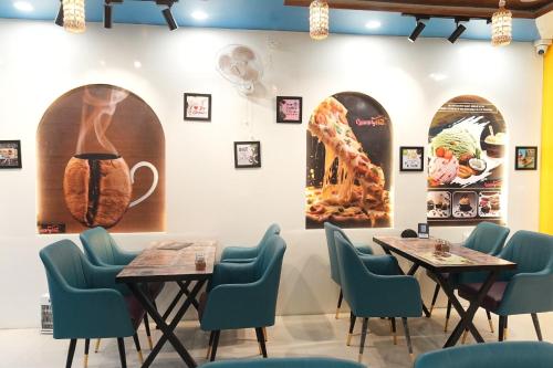 two tables and chairs in a restaurant with pictures on the wall at Hotel Hari Kripa Dham Near Prem Mandir Vrindavan in Vrindāvan