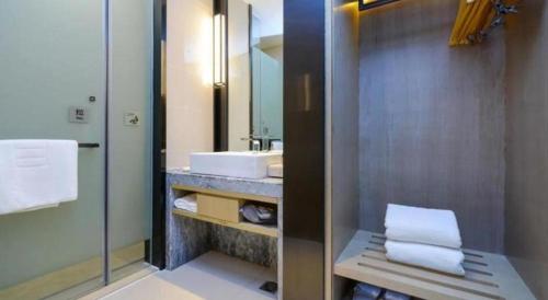 a bathroom with a sink and a mirror at Echarm Hotel Anshun High-speed Railway Station Jichang Road in Anshun