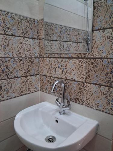 a bathroom with a sink and a mirror at Himalayan Wellness Retreat in Narendranagar
