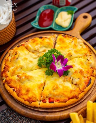 a pizza sitting on a table with a flower on it at Harvest Day Hoi An in Hoi An