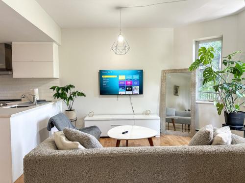 a living room with a couch and a tv at Chic & Fully Furnished 2-Bedroom Apartment in Prestigious Westmount in Montréal