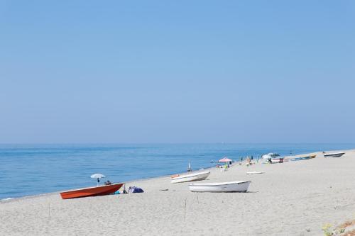 a group of boats on a beach near the water at B&B Casa Cosmano in Brancaleone Marina