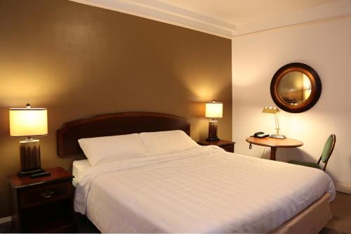 um quarto com uma cama, 2 candeeiros e um espelho em Nash Hotel em Berkeley