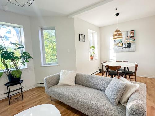 a living room with a couch and a table at Chic & Fully Furnished 2-Bedroom Apartment in Prestigious Westmount in Montréal