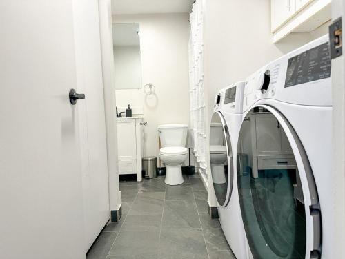 a washer and dryer in a bathroom with a toilet at Chic & Fully Furnished 2-Bedroom Apartment in Prestigious Westmount in Montréal