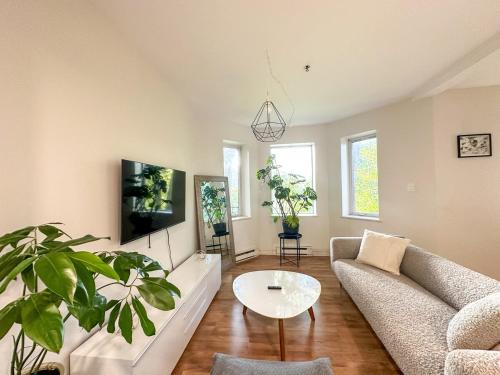 a living room with a couch and a table at Chic & Fully Furnished 2-Bedroom Apartment in Prestigious Westmount in Montréal