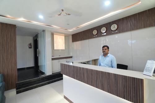 a man standing behind a counter in a room at Hotel Hari Kripa Dham Near Prem Mandir Vrindavan in Vrindāvan