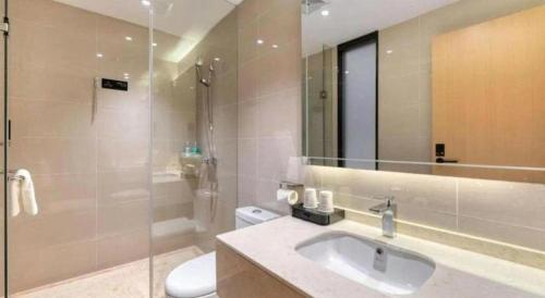 a bathroom with a sink and a toilet and a mirror at City Comfort Inn Lijiang Ancient Town in Lijiang