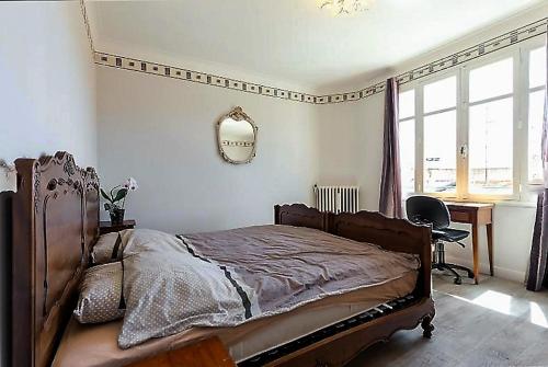 una camera con letto, scrivania e specchio di Villa Lerina a Cannes