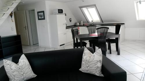 Una sala de estar con un sofá negro y una mesa. en Country and Town, en Unterhaching
