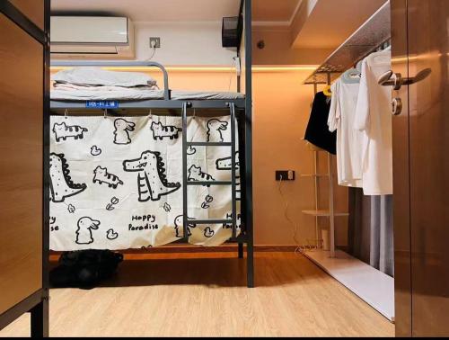 a bunk bed in a room with clothes at 蓝奋斗者男生青旅-深圳北站店 in Lung Wa