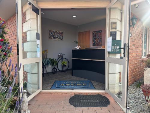 an open door leading into a home with a rug at ASURE Ambassador Motor Lodge in Oamaru