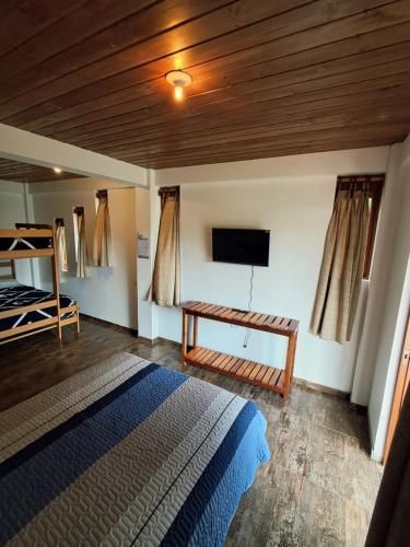 a bedroom with a bed and a flat screen tv at BellaVista 2 habitaciones con balcón in Oxapampa