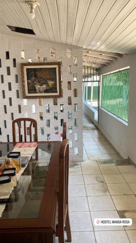 a dining room with a table and a picture on the wall at Hostel Manga Rosa Stm in Santarém