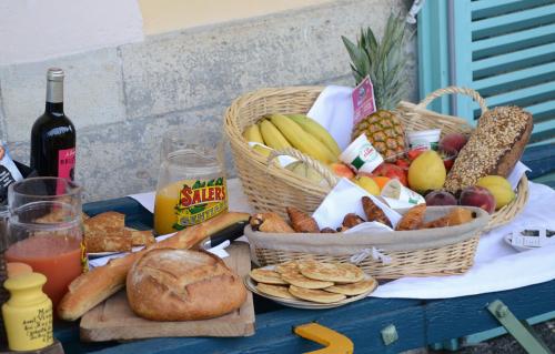un tavolo con cesti di frutta e pane e una bottiglia di vino di Avenue de la Gare a Riscle