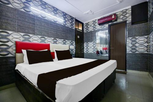 a bedroom with a large bed with a red headboard at Hotel O K10 Grand in Ludhiana