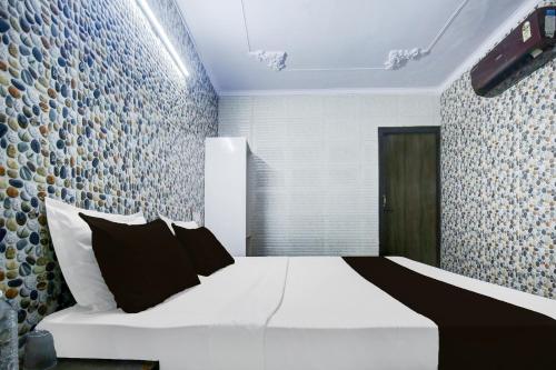 a bedroom with a bed with black and white pillows at Hotel O K10 Grand in Ludhiana
