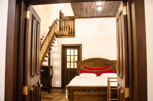 a bedroom with a bed in a hallway with a staircase at Bungalow 1926 in Nuwara Eliya