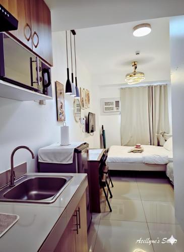 a kitchen with a sink and a room with a bed at Acellyne's Suites at Green 2 Residences with Netflix! in Dasmariñas