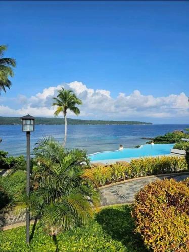 a view of a swimming pool and the ocean at Kembali Condo Unit For Rent in Magamomo