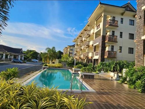 a hotel with a swimming pool in front of a building at Kembali Condo Unit For Rent in Magamomo