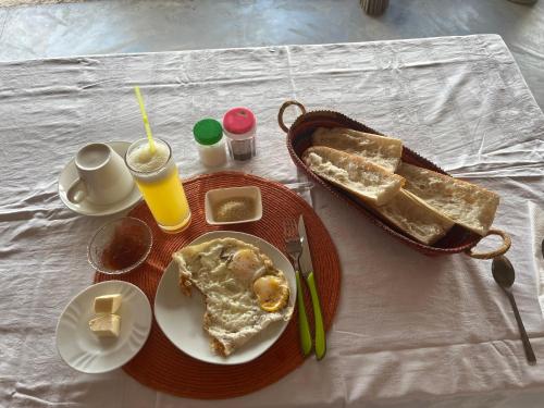 una mesa con un plato de comida y pan para el desayuno en Le Rocher, en Sainte Marie