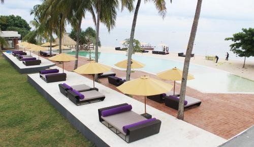 an overhead view of a pool with lounge chairs and umbrellas at Anema Wellness & Resort Gili Lombok - Diving Center PADI in Tanjung