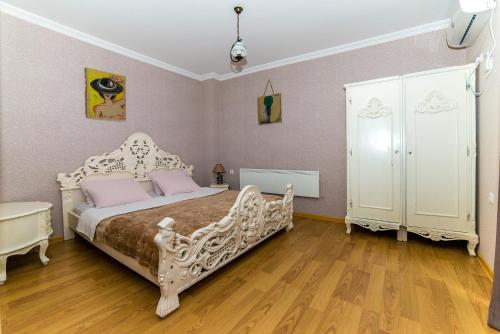 a bedroom with a white bed with pink pillows at Hillside Resort Telavi in Telavi