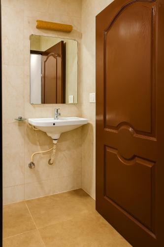 a bathroom with a sink and a mirror at The Grantley Hotel - Alibag Beach in Alibag