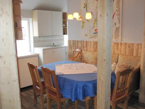 a kitchen with a table with chairs and a blue table cloth at Gamla Skolan Bed And Breakfast in Gubbhögen