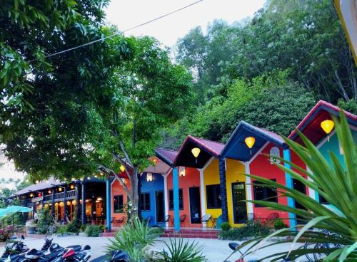 a colorful building with motorcycles parked in front of it at Woodstock Beach Camp in Cat Ba