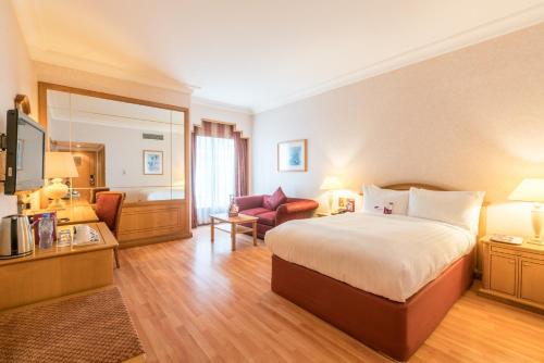 a hotel room with a bed and a living room at Millennium Downtown in Abu Dhabi