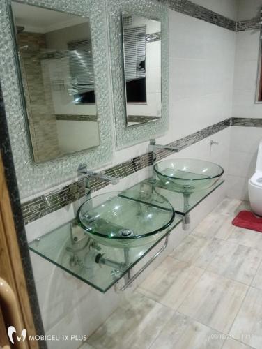 a bathroom with two glass sinks and a mirror at Divas Guest house in Midrand