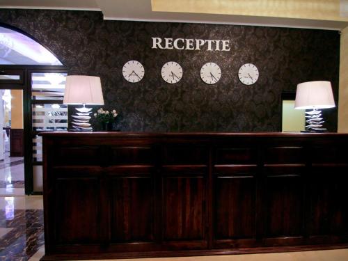 a reception desk with clocks on the wall at Laura Holiday in Brăila