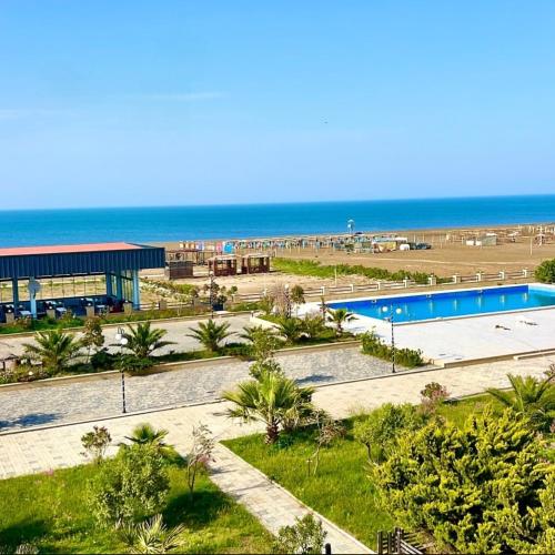 a resort with a swimming pool and the beach at Delmar in Baku