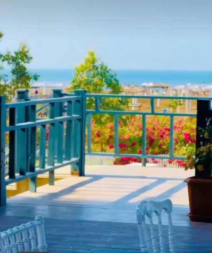 two chairs on a deck with a fence and flowers at Delmar in Baku