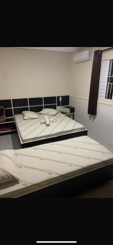 a bedroom with two beds with white sheets at Hotel Maya in São Paulo