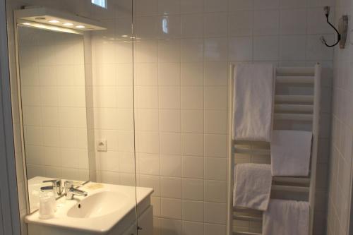 a bathroom with a sink and a mirror at Hotel Des Falaises in Villers-sur-Mer