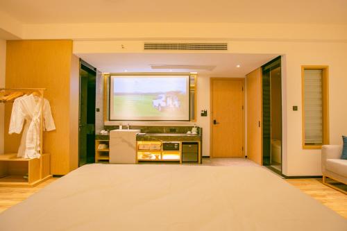 a living room with a flat screen tv and a dressing room at 桂林阳朔良宿 LS Hotel Liangsu Yangshuo in Gaotian