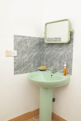 a bathroom with a sink and a mirror on the wall at StayEase in Batticaloa