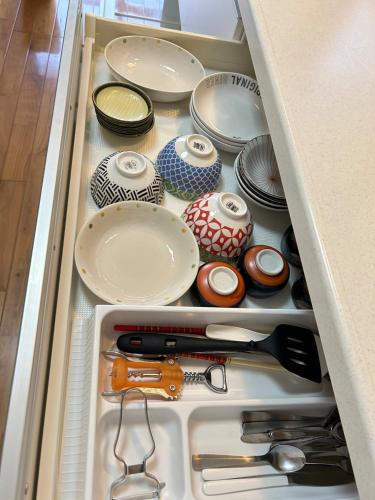 a drawer filled with plates and othercellaneous items at Minnpaku nami - Vacation STAY 60554v in Awara