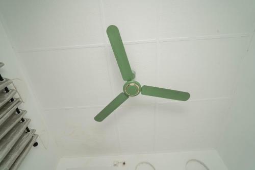 a green ceiling fan hanging from a white ceiling at StayEase in Batticaloa