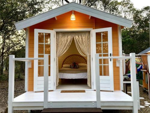a small orange house with a bed in it at Casa Naranja - Off-grid Hideaway Agnes Water 1770 in Agnes Water