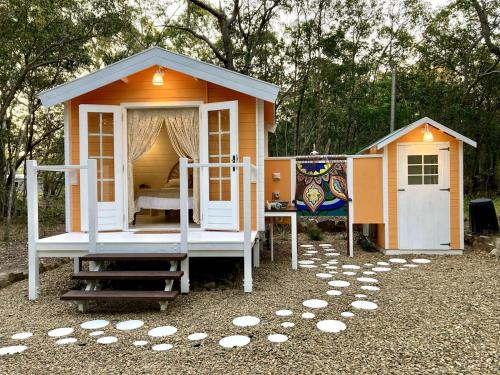 a small house with a bed in the yard at Casa Naranja - Off-grid Hideaway Agnes Water 1770 in Agnes Water