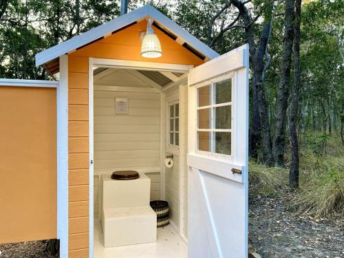 a small shed with an orange roof and a door at Casa Naranja - Off-grid Hideaway Agnes Water 1770 in Agnes Water