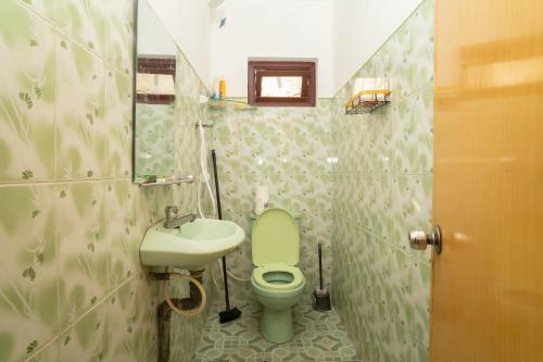 a bathroom with a green toilet and a sink at StayEase in Batticaloa