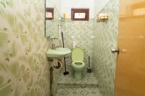 a bathroom with a green toilet and a sink at StayEase in Batticaloa
