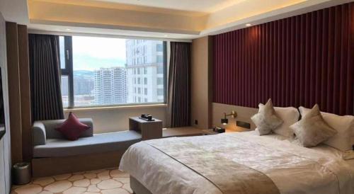 a bedroom with a large bed and a large window at Yanji Yanbian International Hotel in Yanji