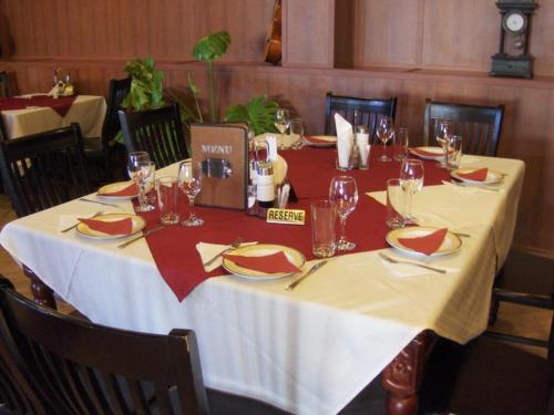 einen Tisch mit einem weißen Tischtuch und Weingläsern in der Unterkunft Hotel Kibor in Gŭlŭbovo